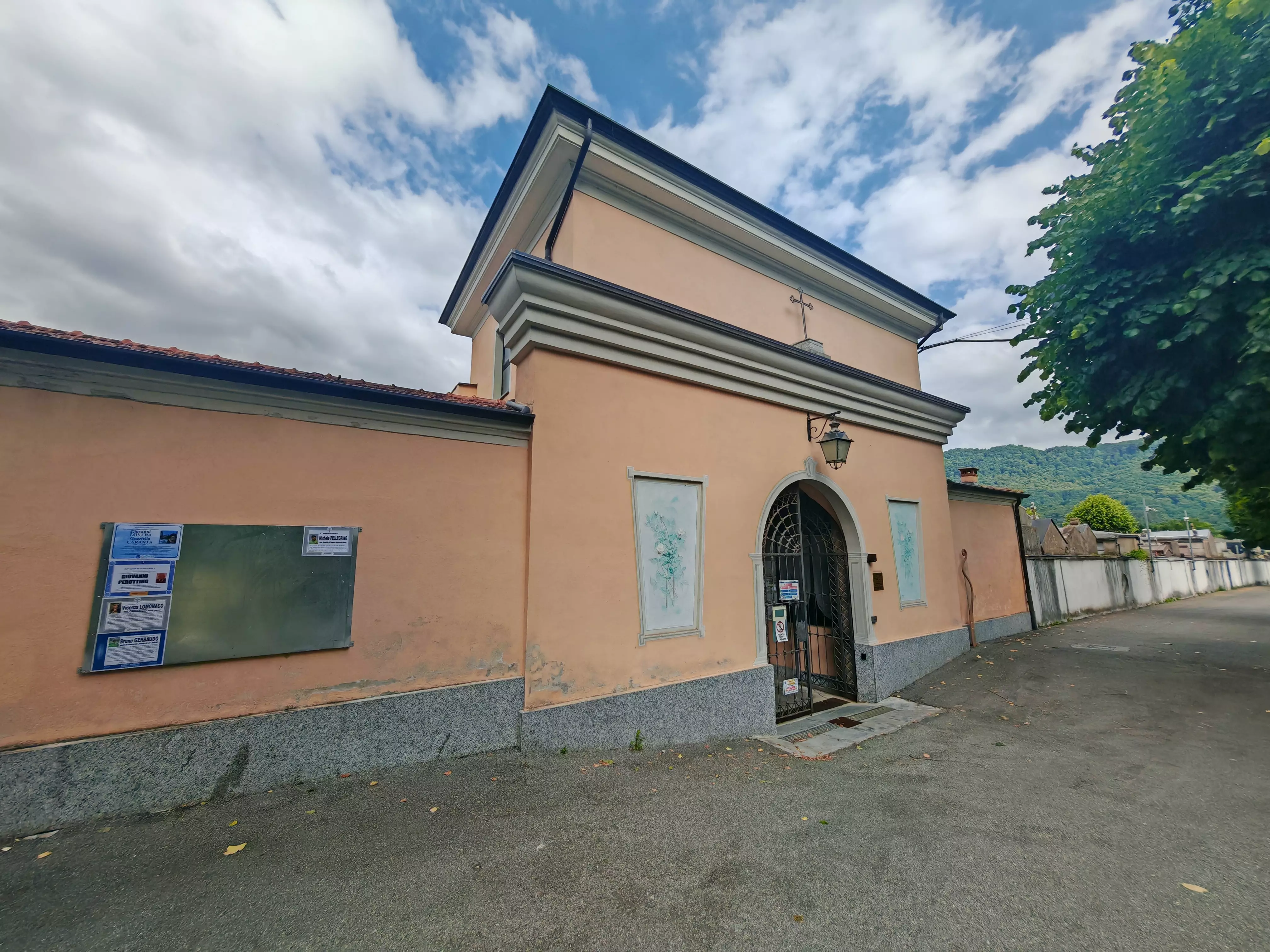 L’ingresso del cimitero di Borgo San Dalmazzo. A lato il nuovo tabellone necrologi